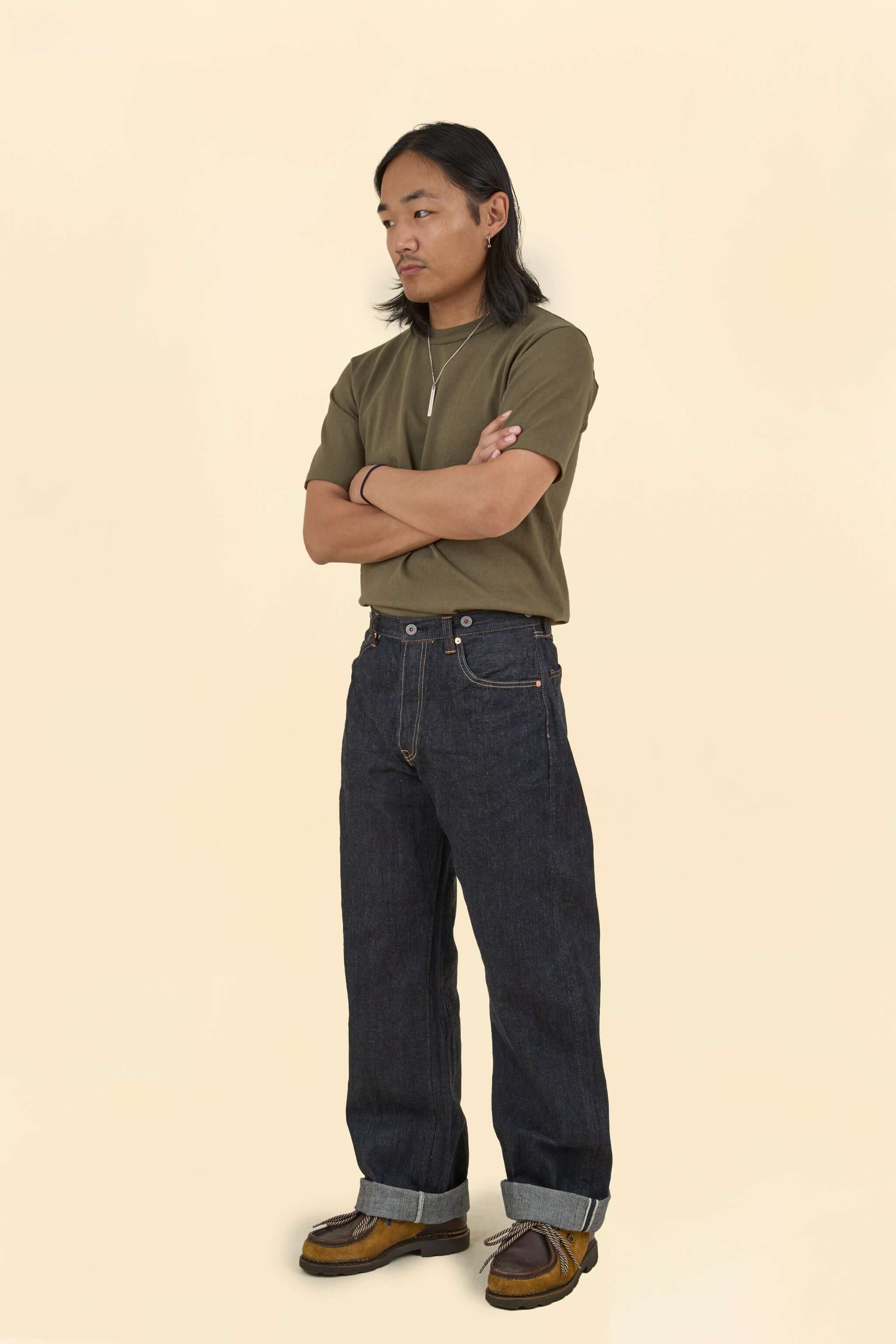 Model wearing Graph Zero Heritage Denim - 13oz styled with a casual olive green t-shirt and brown shoes.